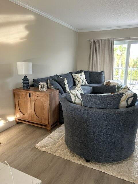 A living room features a dark blue sectional sofa, a wooden cabinet, and light flooring — 311 E Ocean Avenue # 309, Lantana FL 33462, LANTANA, FL