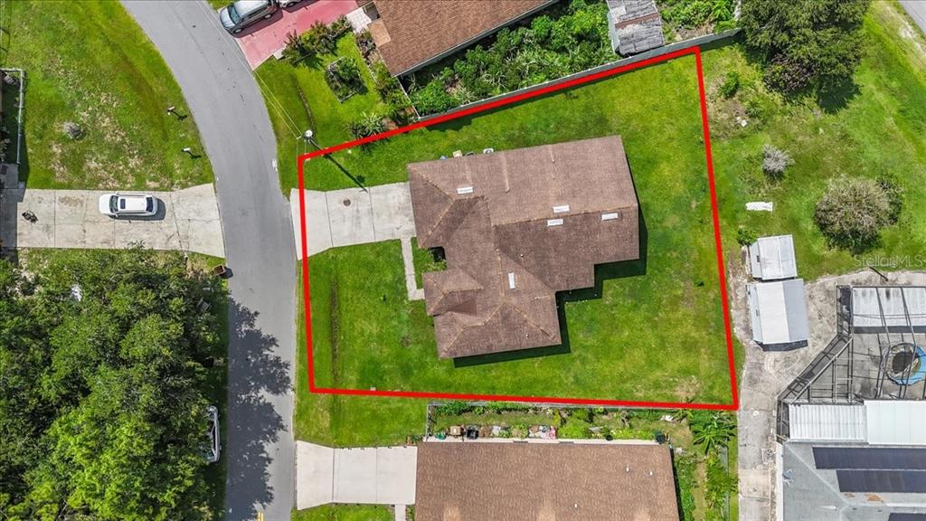 An aerial view shows a single-story house with a brown roof on a grassy lot — 1147 DONCASTER COURT, KISSIMMEE, FL