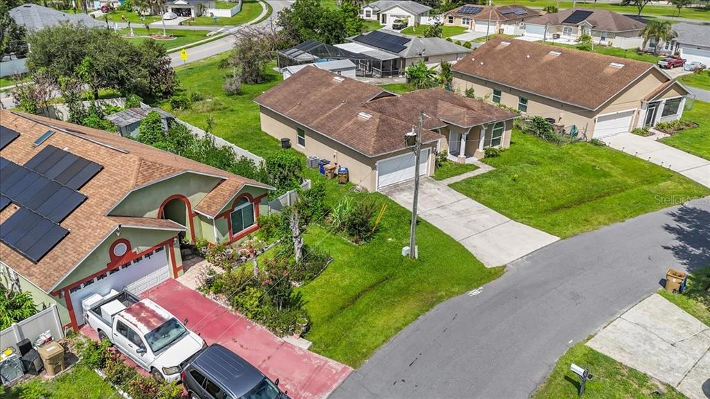 An aerial view shows two suburban houses with driveways and solar panels on their roofs — 1147 DONCASTER COURT, KISSIMMEE, FL