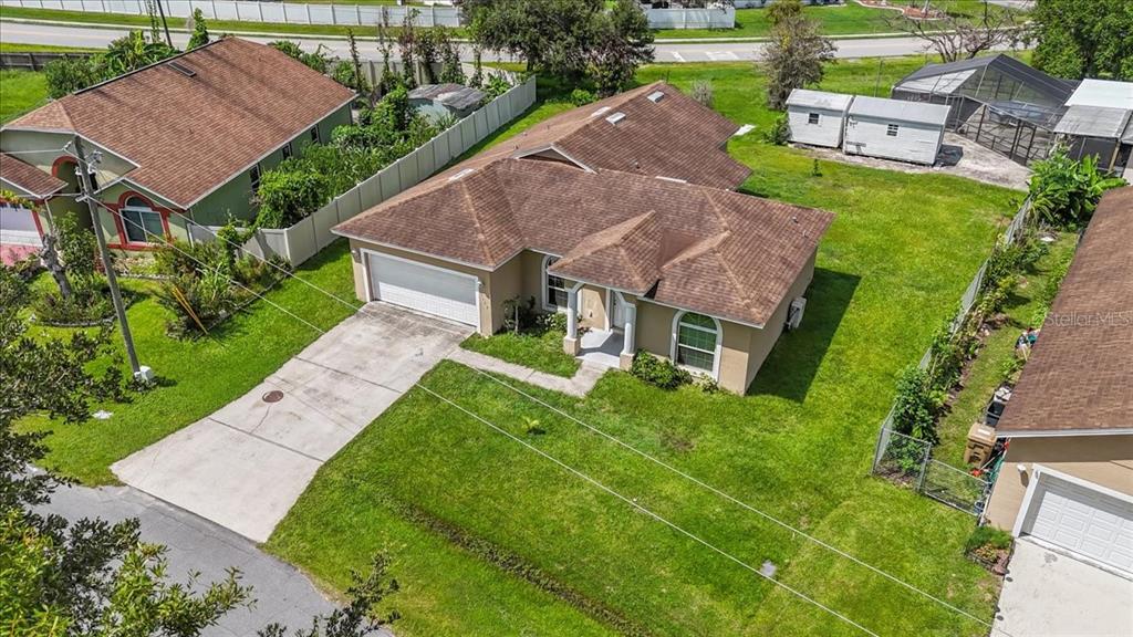 An aerial view shows a single-story house with a brown roof and a concrete driveway — 1147 DONCASTER COURT, KISSIMMEE, FL