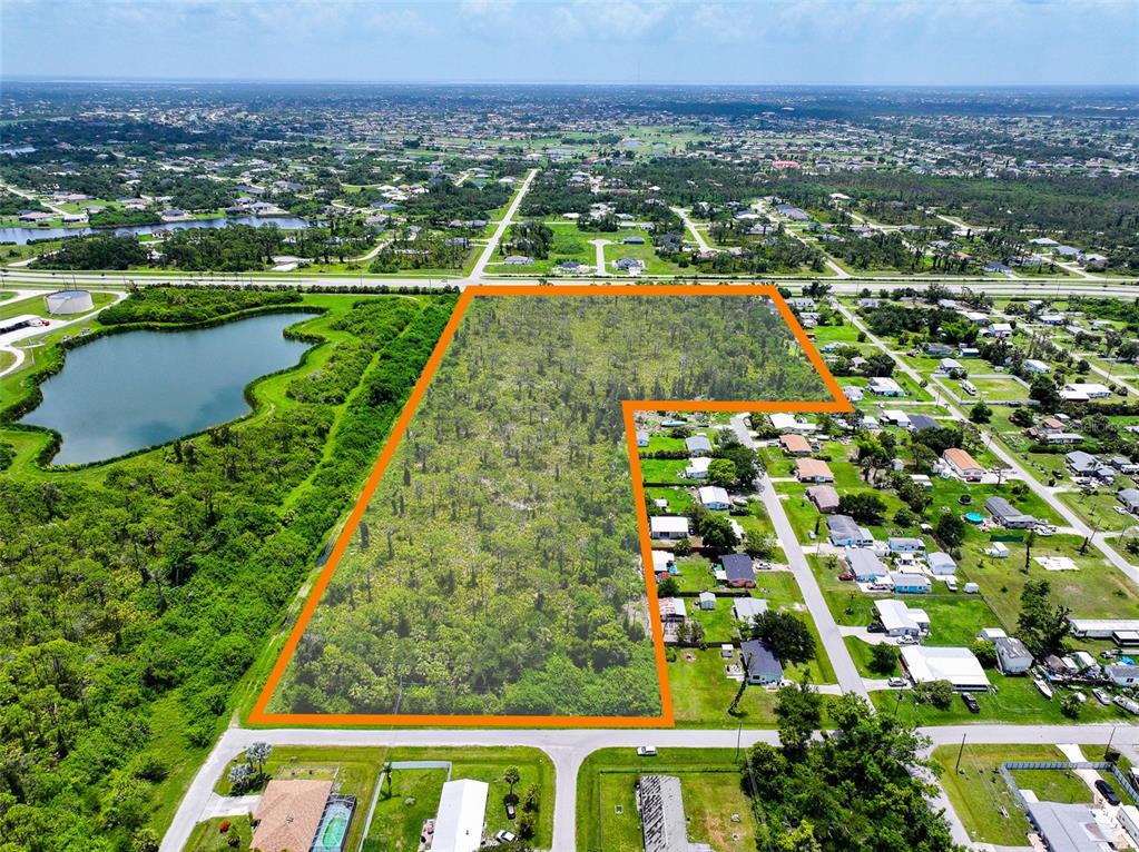 An aerial view shows a large, L-shaped wooded lot outlined in orange next to residential homes — 8399 CYPRESS ROAD, ENGLEWOOD, FL