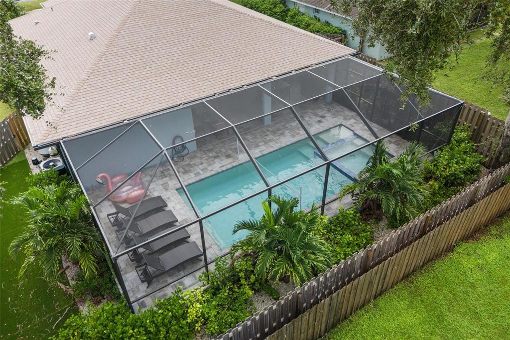 An aerial view of a backyard swimming pool enclosed by a screened lanai and fence — 4360 IOLA DRIVE, SARASOTA, FL