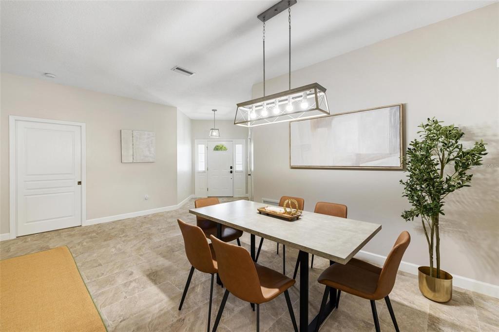 A dining room features a rectangular table, six brown chairs, and a modern light fixture — 4360 IOLA DRIVE, SARASOTA, FL