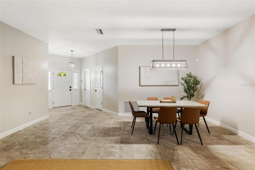 A dining area with a rectangular table, six brown chairs, and a modern light fixture — 4360 IOLA DRIVE, SARASOTA, FL