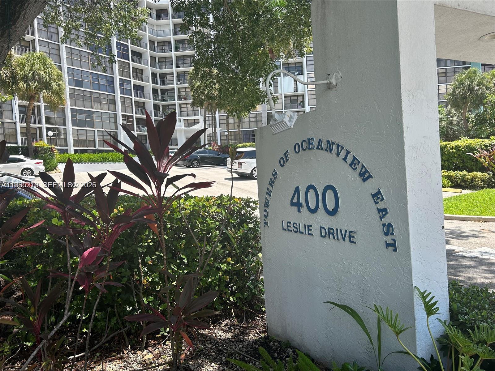 A sign for Towers of Oceanview East stands in front of a multi-story apartment building — 400 Leslie Dr # 308, Hallandale Beach FL 33009, HALLANDALE BEACH, FL