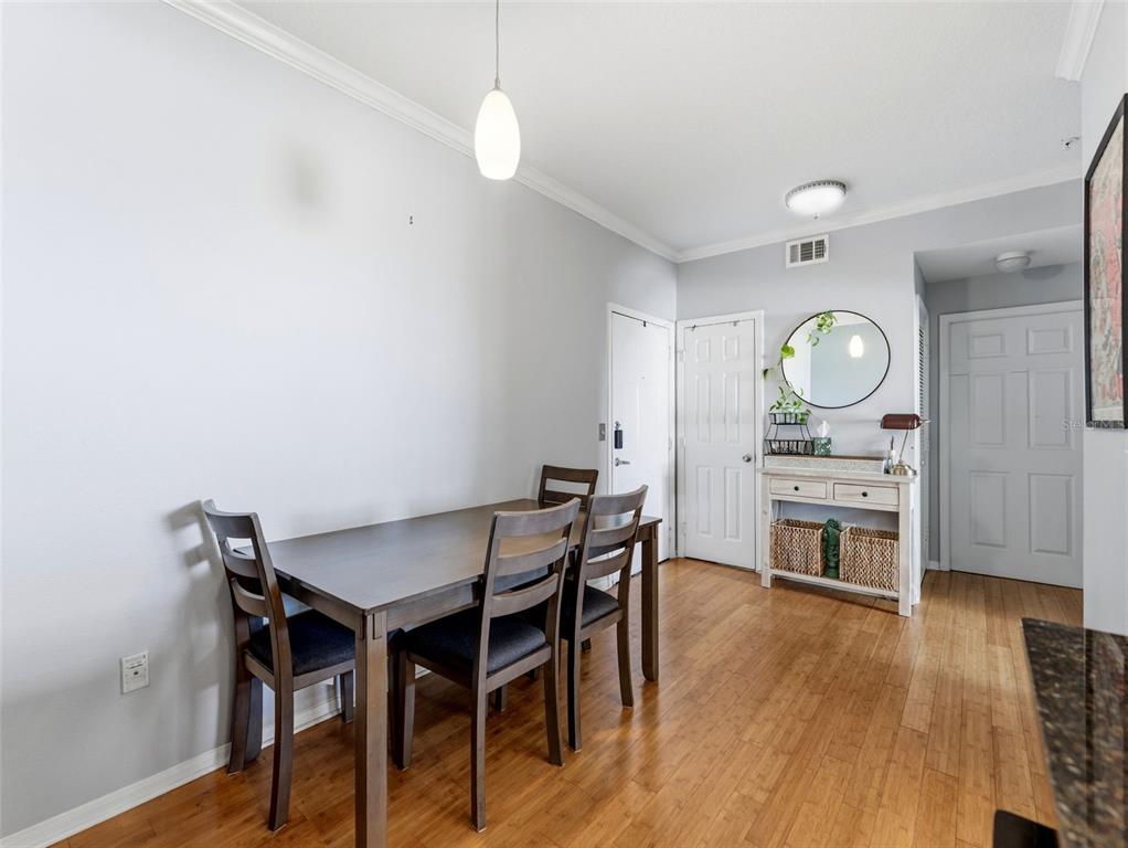 A dining area features a dark wood table, four chairs, and a console table — 501 KNIGHTS RUN AVENUE UNIT 1325, TAMPA, FL