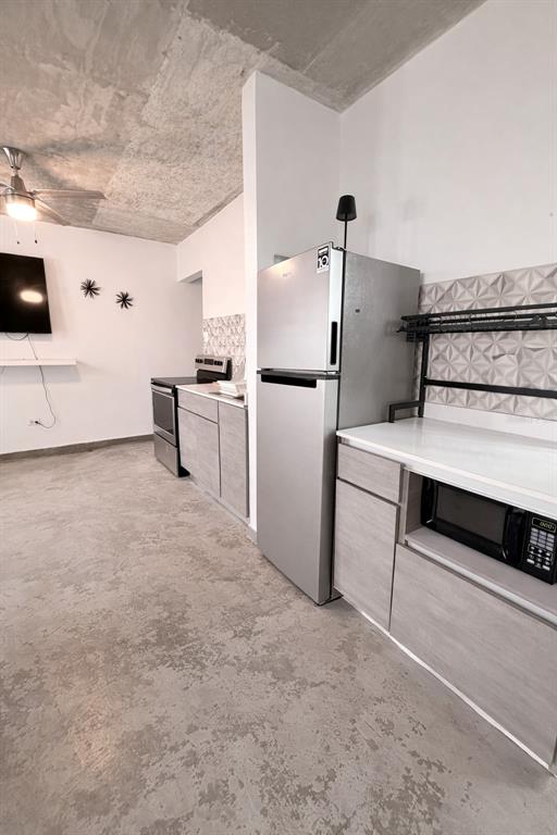 A kitchen with stainless steel appliances, light wood cabinets, and a concrete ceiling — 45 BARCELONA, GUAYAMA, PR