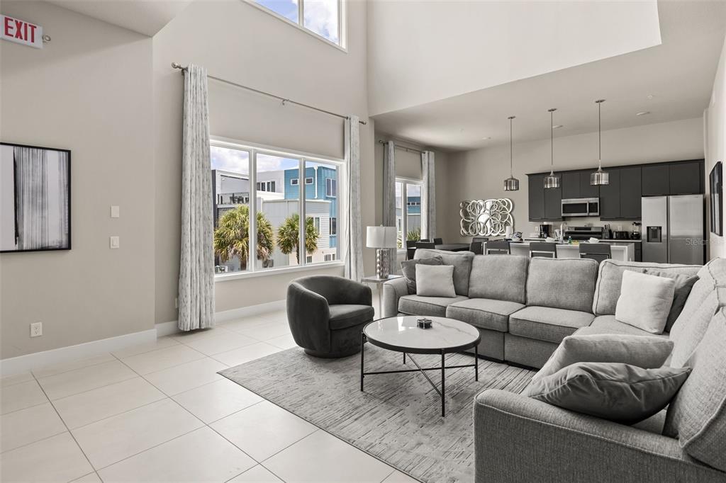 A living room with a sectional sofa, round coffee table, and an open-concept kitchen — 7770 SANDY RIDGE DRIVE UNIT 227, REUNION, FL