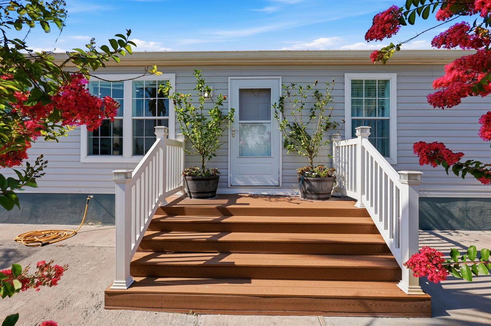 A wooden staircase leads to the front door of a house with light gray siding — 13311 Dancy Avenue, Clewiston FL 33440, CLEWISTON, FL