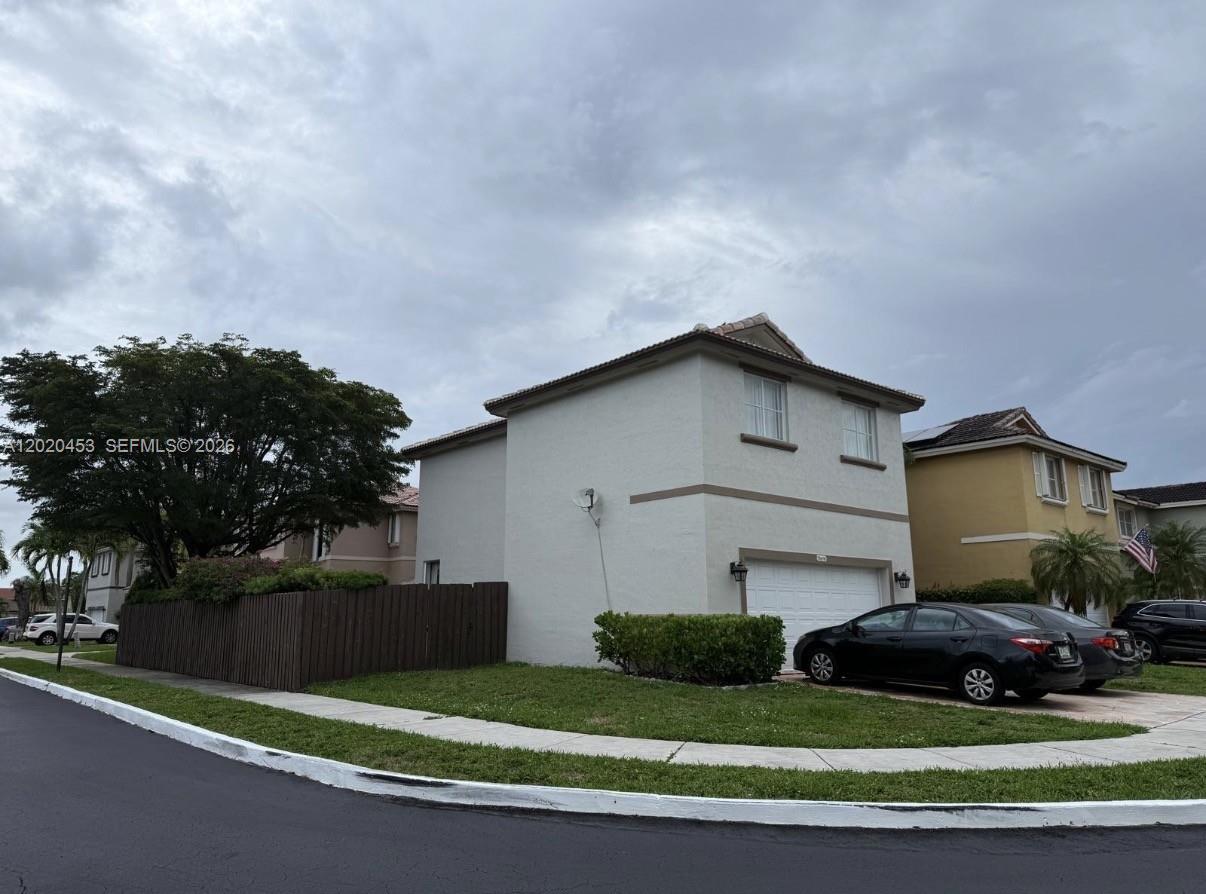 A two-story suburban house with a white stucco exterior and a two-car garage — 15619 SW 112th Dr, Miami FL 33196, MIAMI, FL