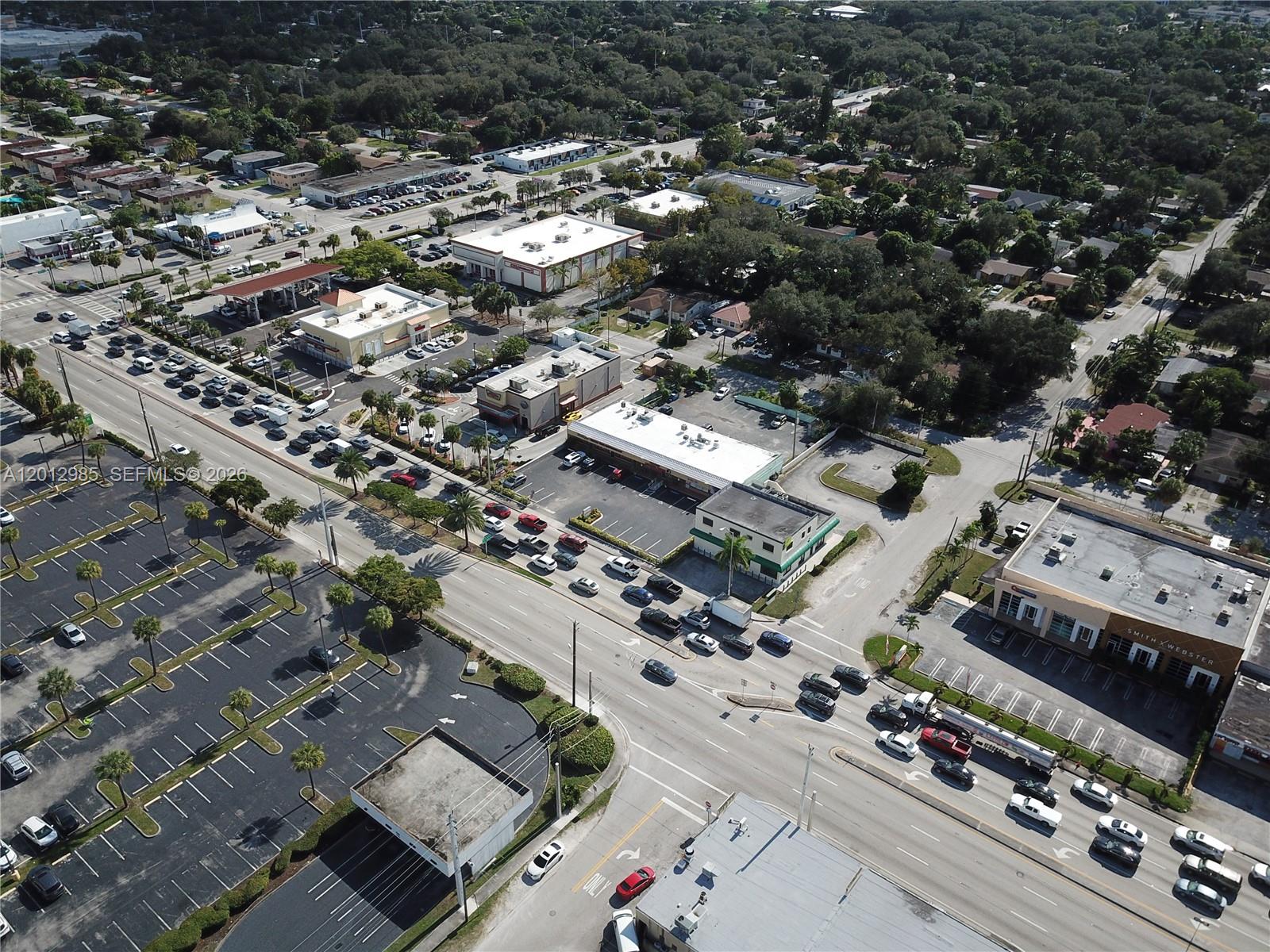 An aerial view shows a commercial area with parking lots, retail buildings, and a busy road — 510 NE 167th St # 510, Miami FL 33162, MIAMI, FL
