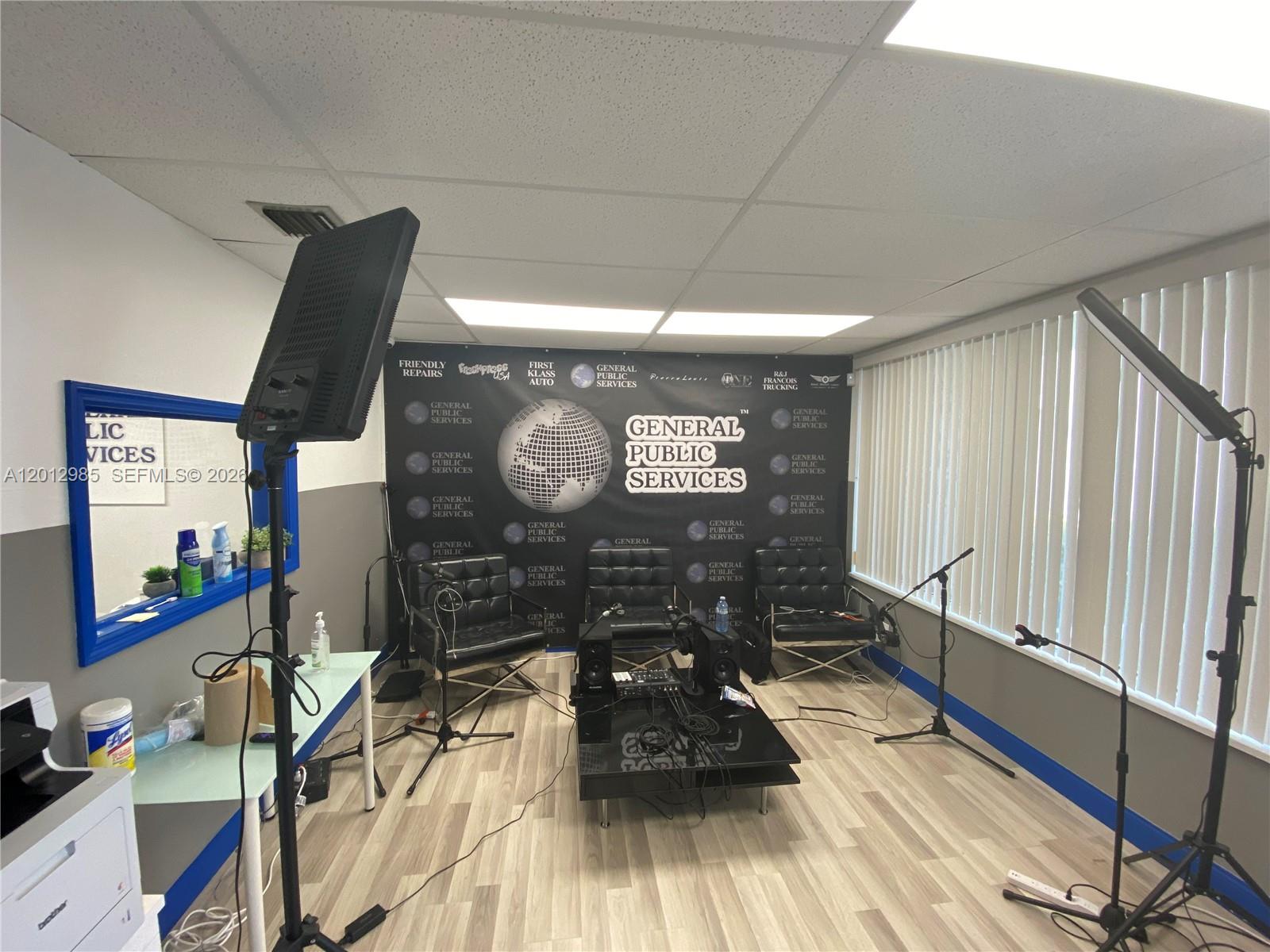 A podcast studio features three black leather chairs, a central table, microphones, and lighting equipment — 510 NE 167th St # 510, Miami FL 33162, MIAMI, FL