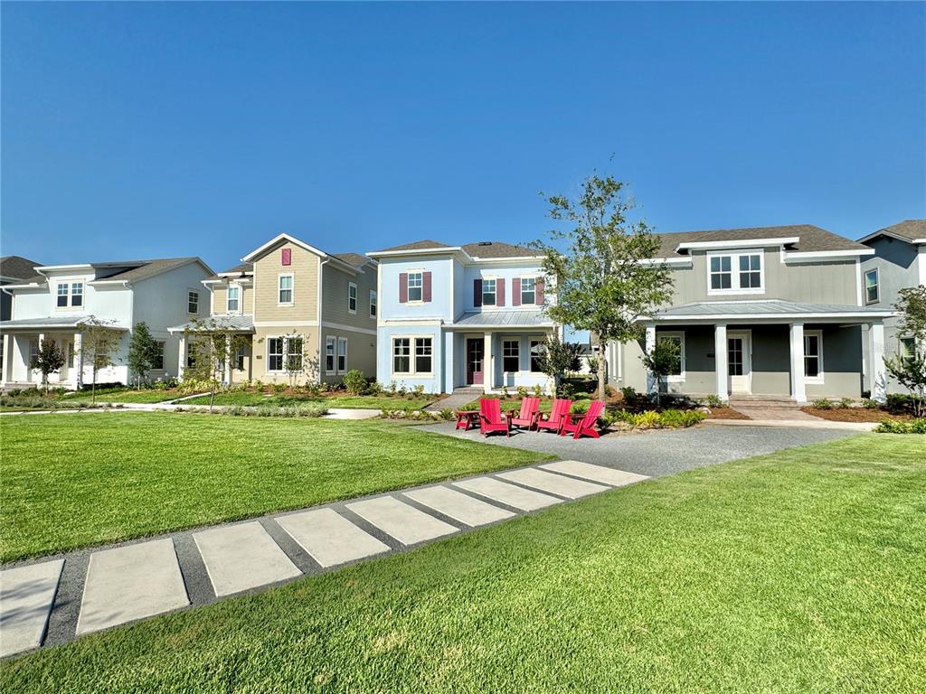 A row of colorful suburban houses faces a grassy lawn with a stone walkway — 13352 LEGGETT ALLEY, ORLANDO, FL