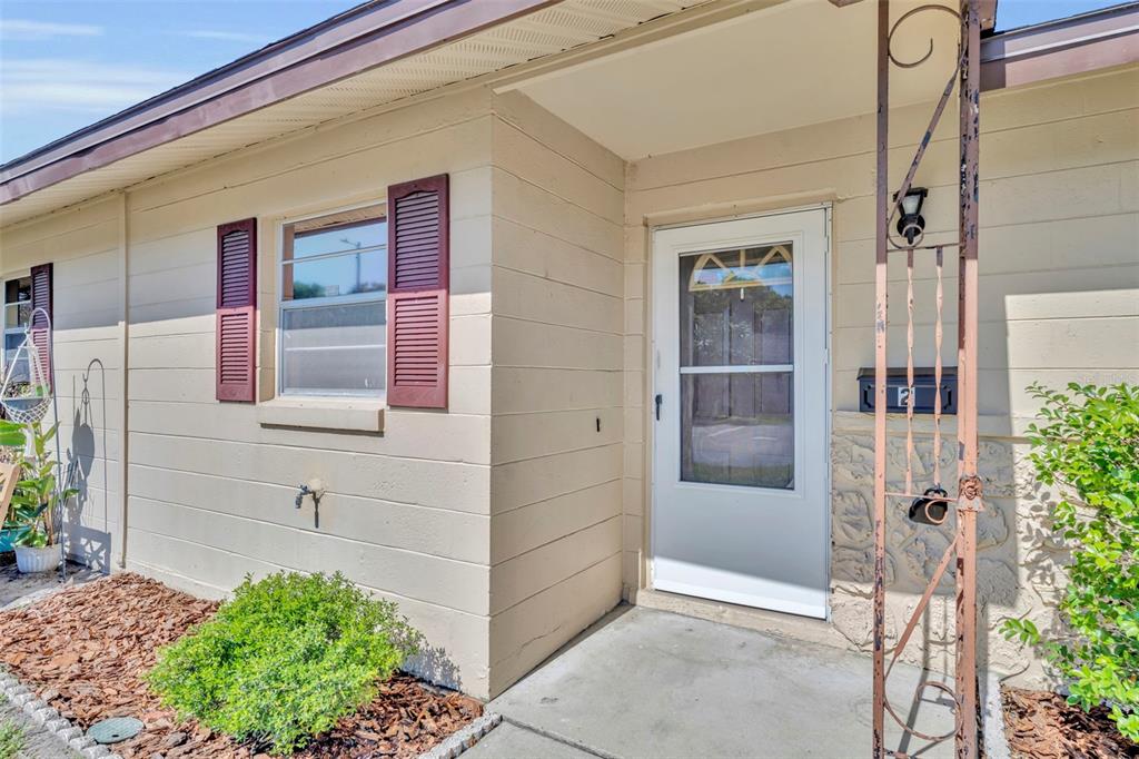 A kitchen features white shaker cabinets, stainless steel appliances, and light wood-look flooring — 2 VILLA VILLAR COURT UNIT 20, DELAND, FL