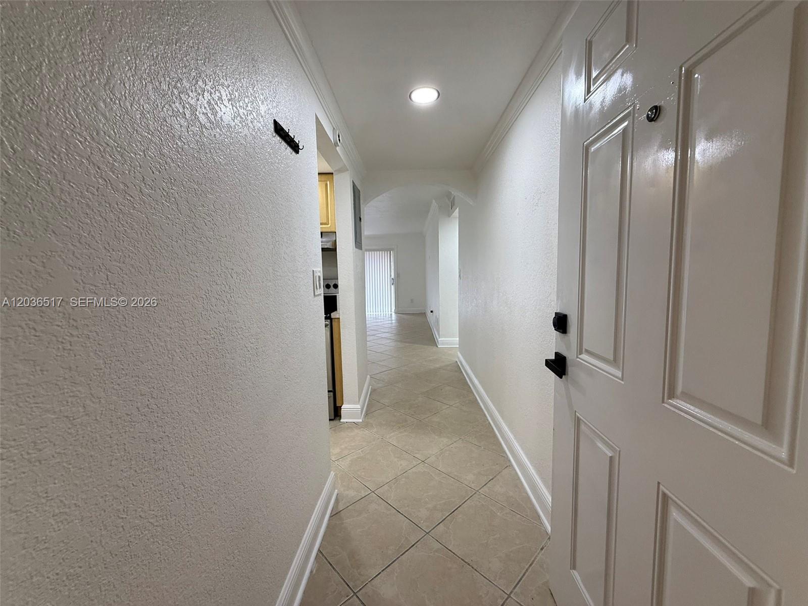 A tiled hallway leads from an entryway toward a kitchen and a bright living area — 8500 SW 109th Ave # 109, Miami FL 33173, MIAMI, FL