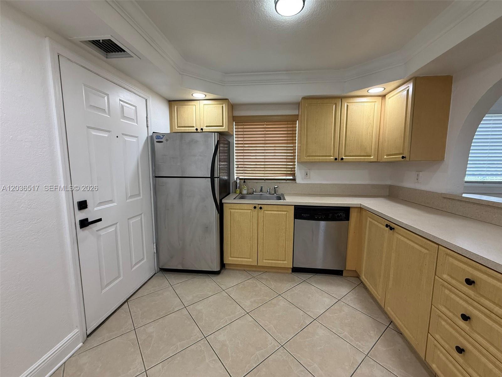 A kitchen features light wood cabinets, stainless steel appliances, and beige tile flooring — 8500 SW 109th Ave # 109, Miami FL 33173, MIAMI, FL