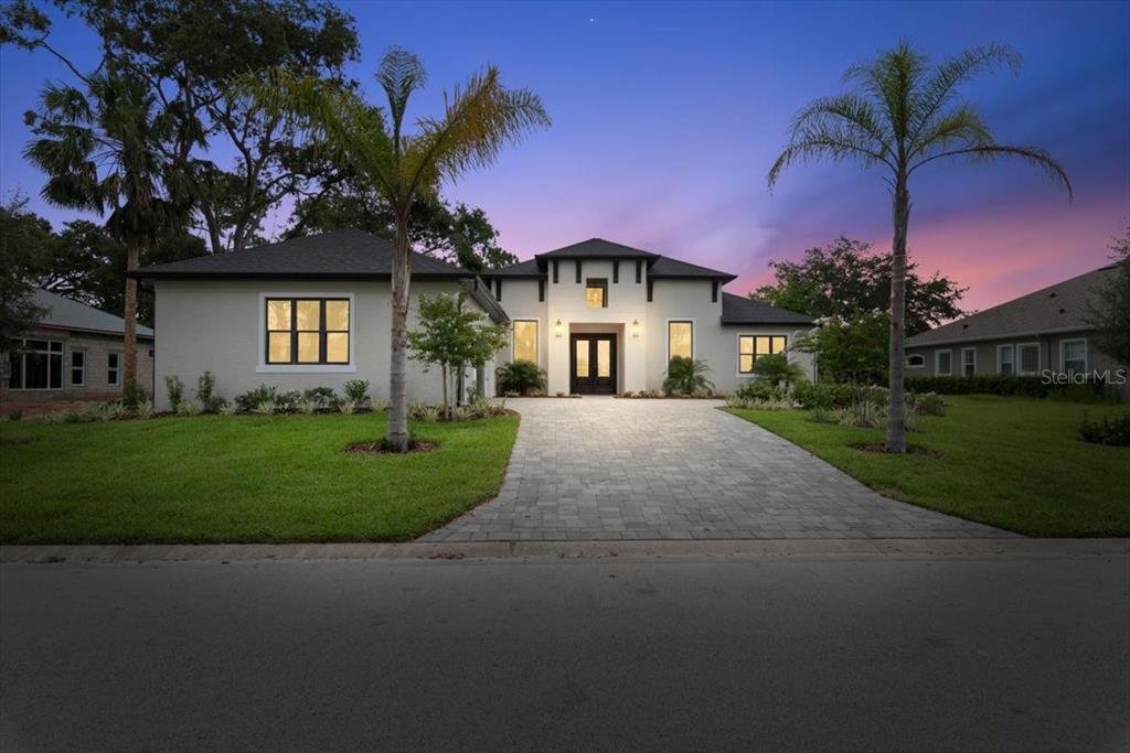 A modern house exterior features a paved driveway, a three-car garage, and a covered entryway — 17 OLD OAK DRIVE N, PALM COAST, FL