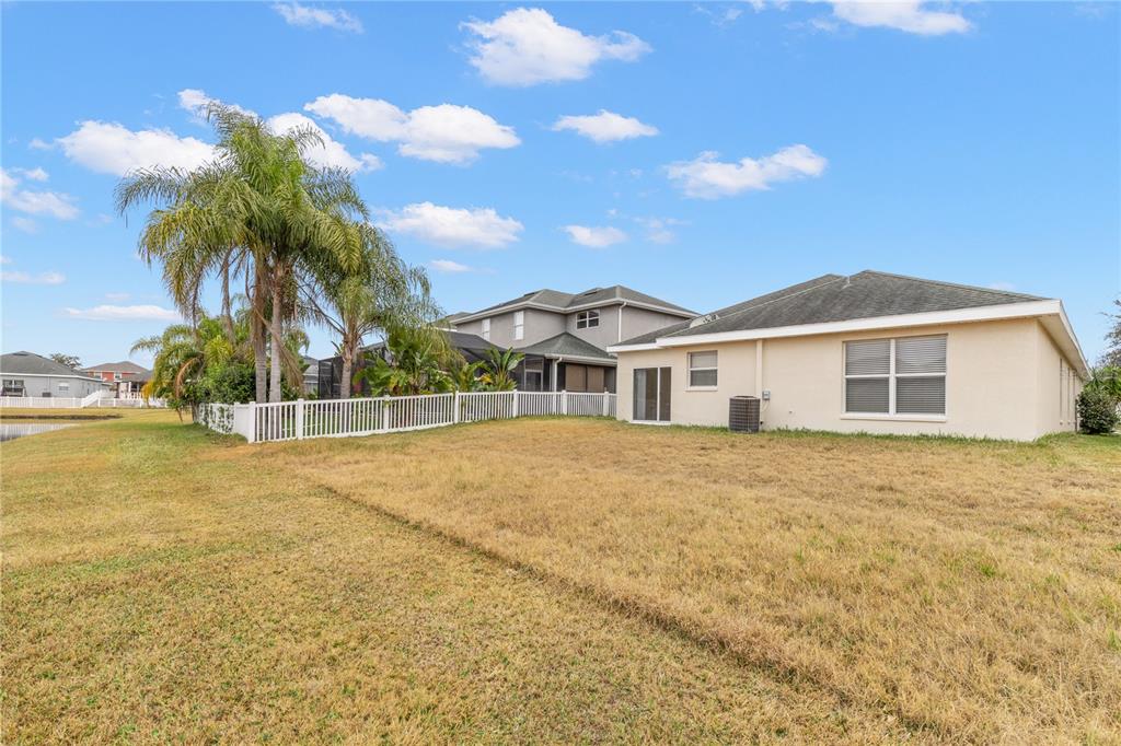 The exterior of a beige house with a large backyard and a white fence — 20011 NOB OAK AVENUE, TAMPA, FL