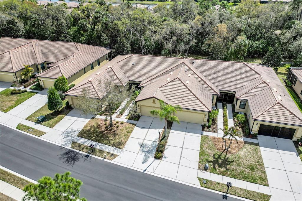 An aerial view shows a row of attached single-story houses with tile roofs and driveways — 420 SENECA FALLS DRIVE, APOLLO BEACH, FL