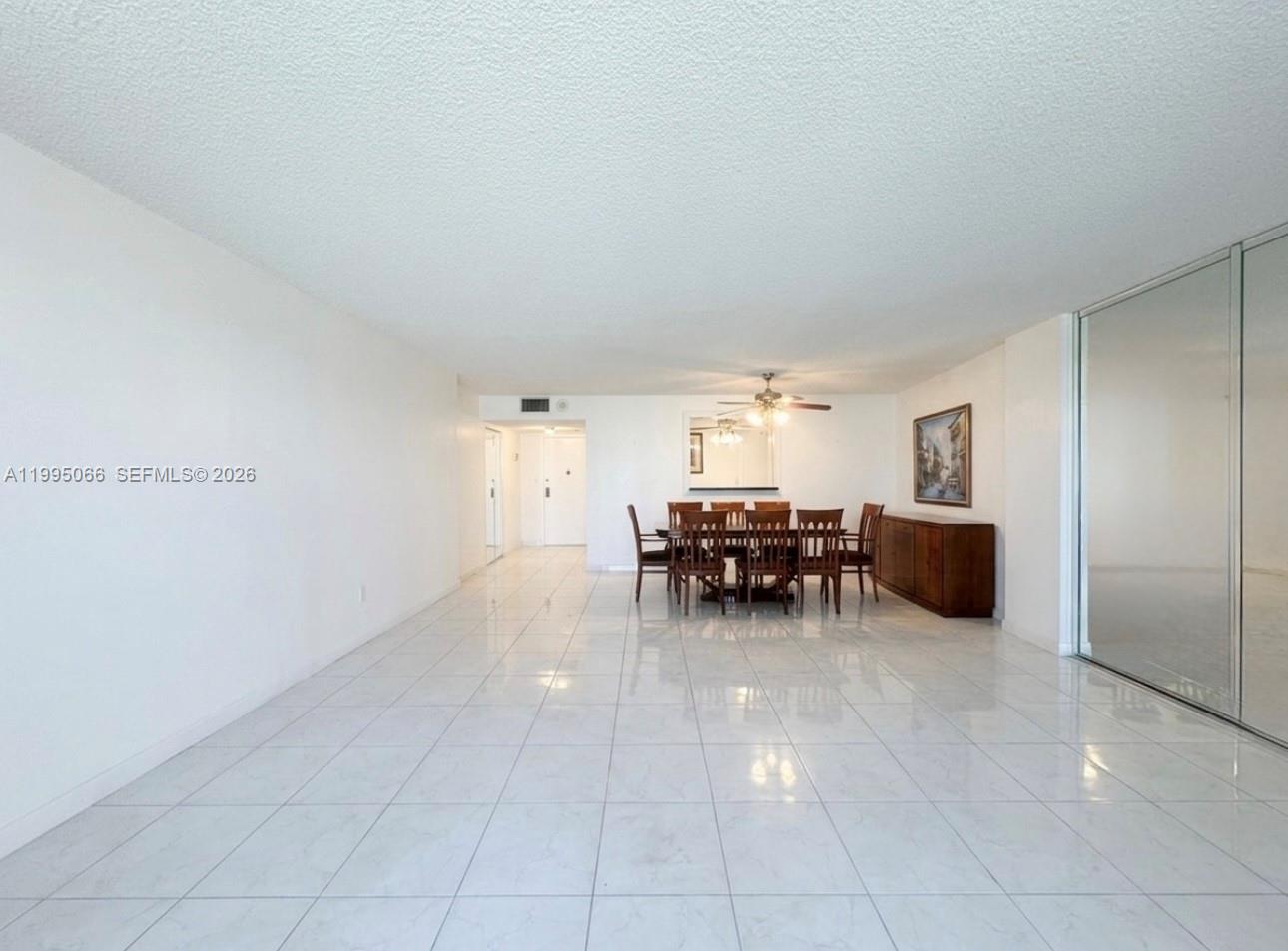 A dining area features white tile flooring, a wooden table with chairs, and mirrored closet doors — 3800 S Ocean Dr # 816, Hollywood FL 33019, HOLLYWOOD, FL