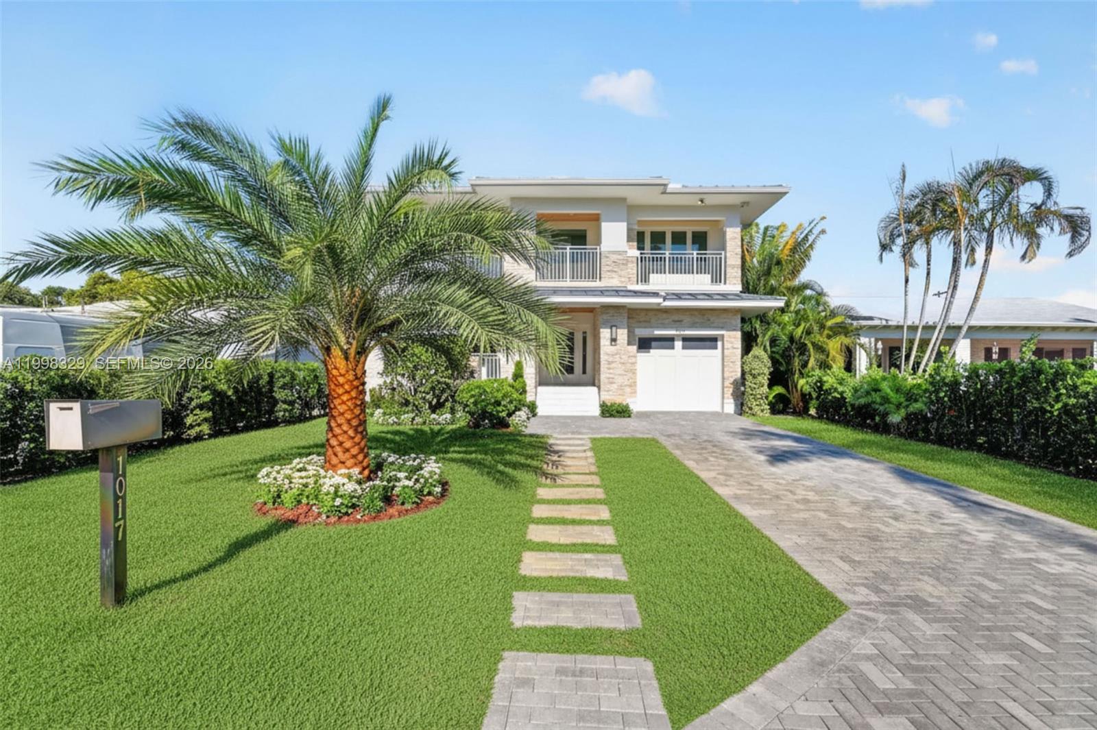 A two-story house features a stone facade, a palm tree, and a paved driveway — 1017 S Palmway, Lake Worth FL 33460, LAKE WORTH, FL