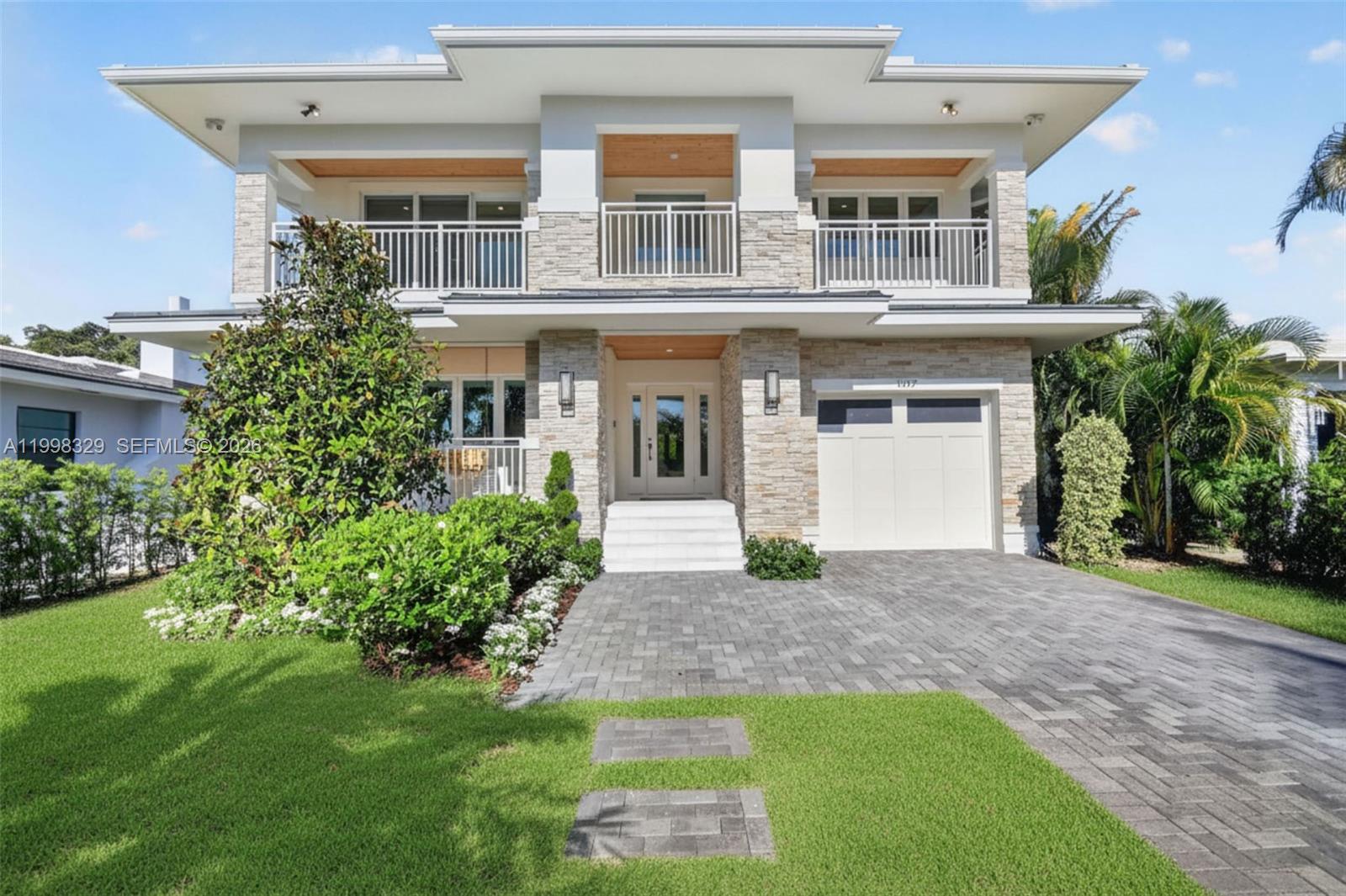 A two-story house features a stone facade, a balcony, and a paved driveway — 1017 S Palmway, Lake Worth FL 33460, LAKE WORTH, FL
