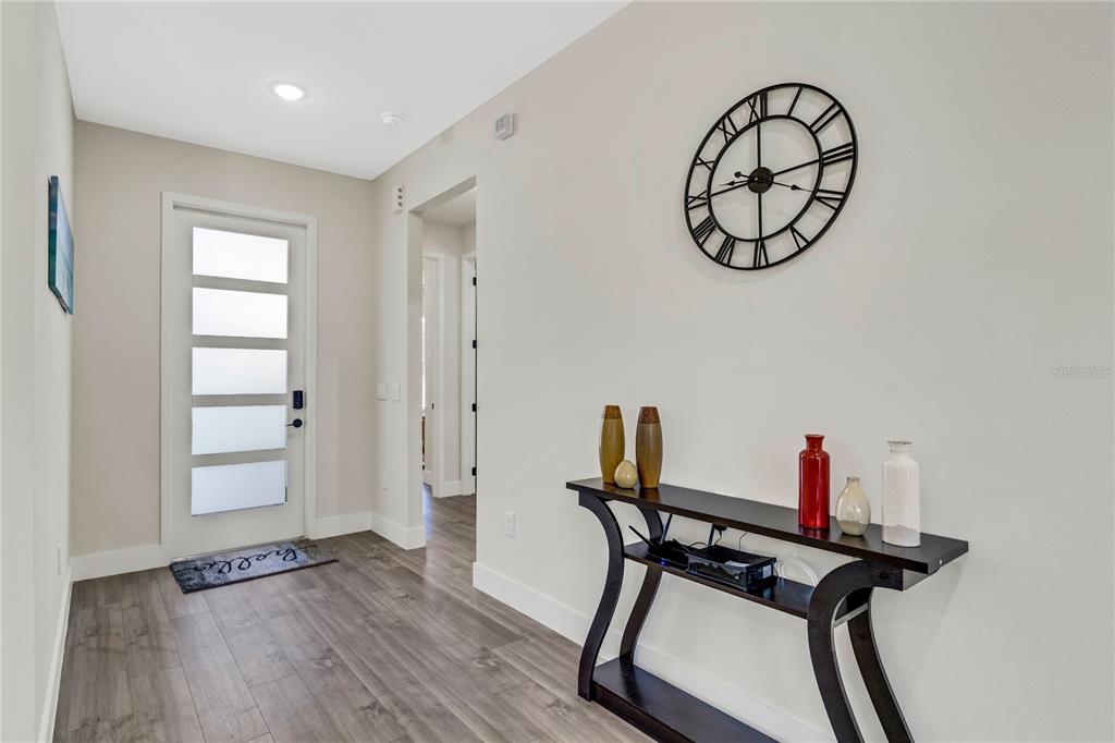 A living room features a sectional sofa, a glass coffee table, and a wall-mounted television — 3724 CORONET AVENUE, ORLANDO, FL