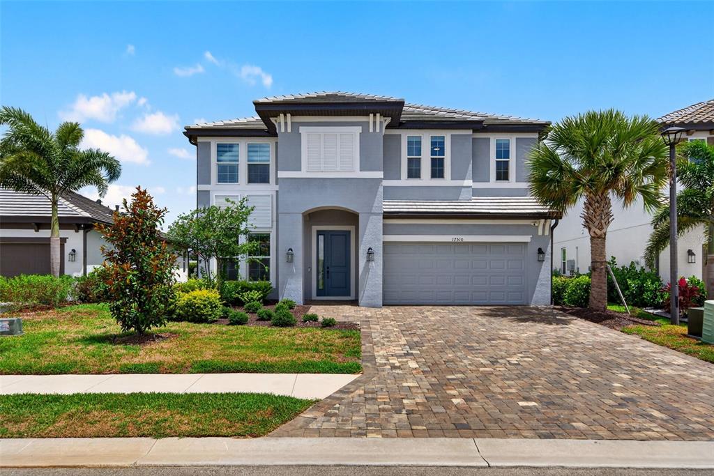 A two-story gray house with a paver driveway, a front porch, and a two-car garage — 17510 SAVORY MIST CIRCLE, BRADENTON, FL