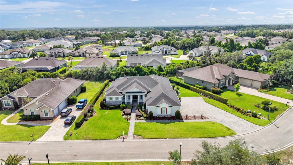 An aerial view shows a suburban neighborhood with several single-family homes and manicured lawns — 6509 HERITAGE PARK PLACE, LAKELAND, FL