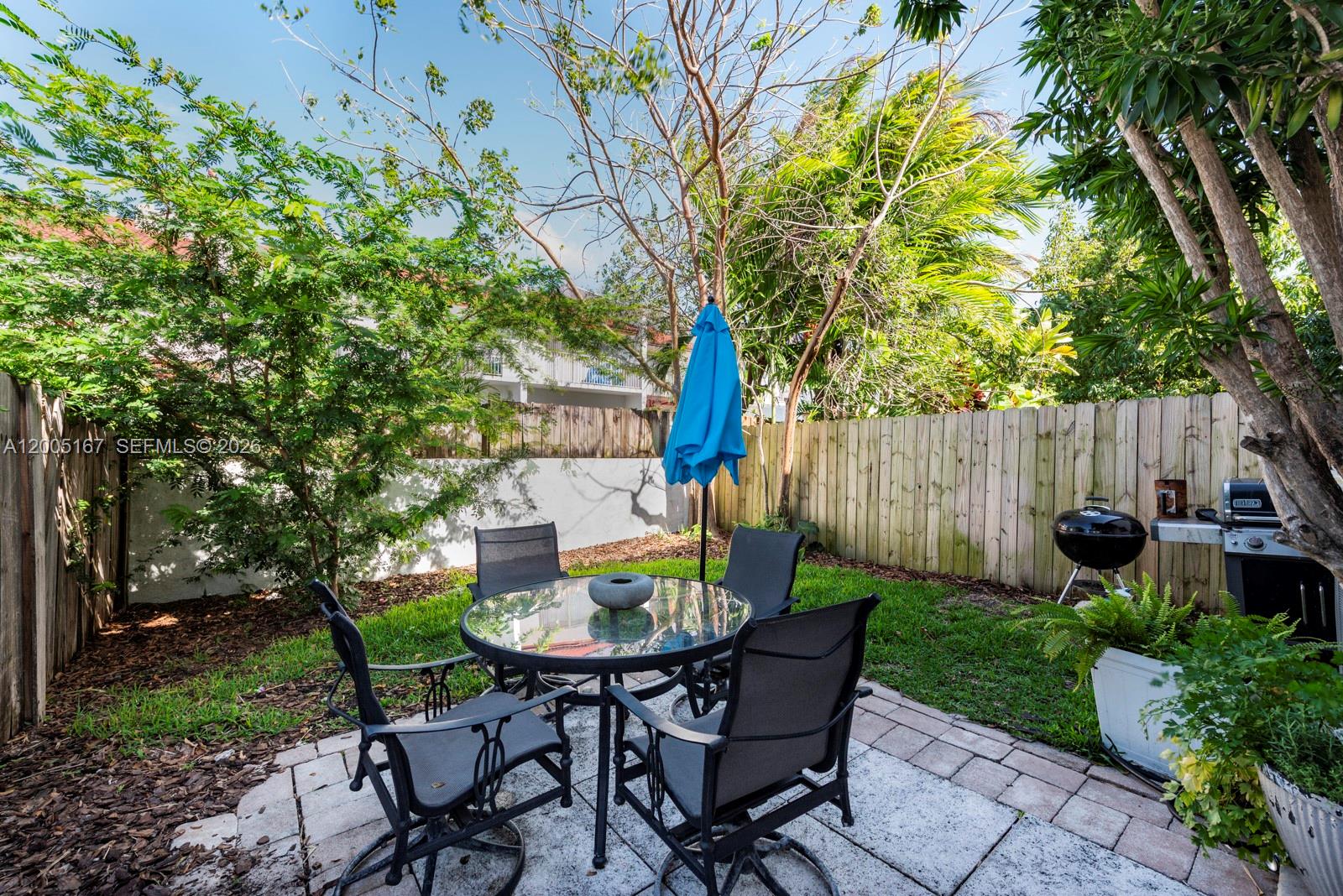 A patio with a glass-topped table, four chairs, a blue umbrella, and a charcoal grill — 20801 SW 83rd Ave, Cutler Bay FL 33189, CUTLER BAY, FL
