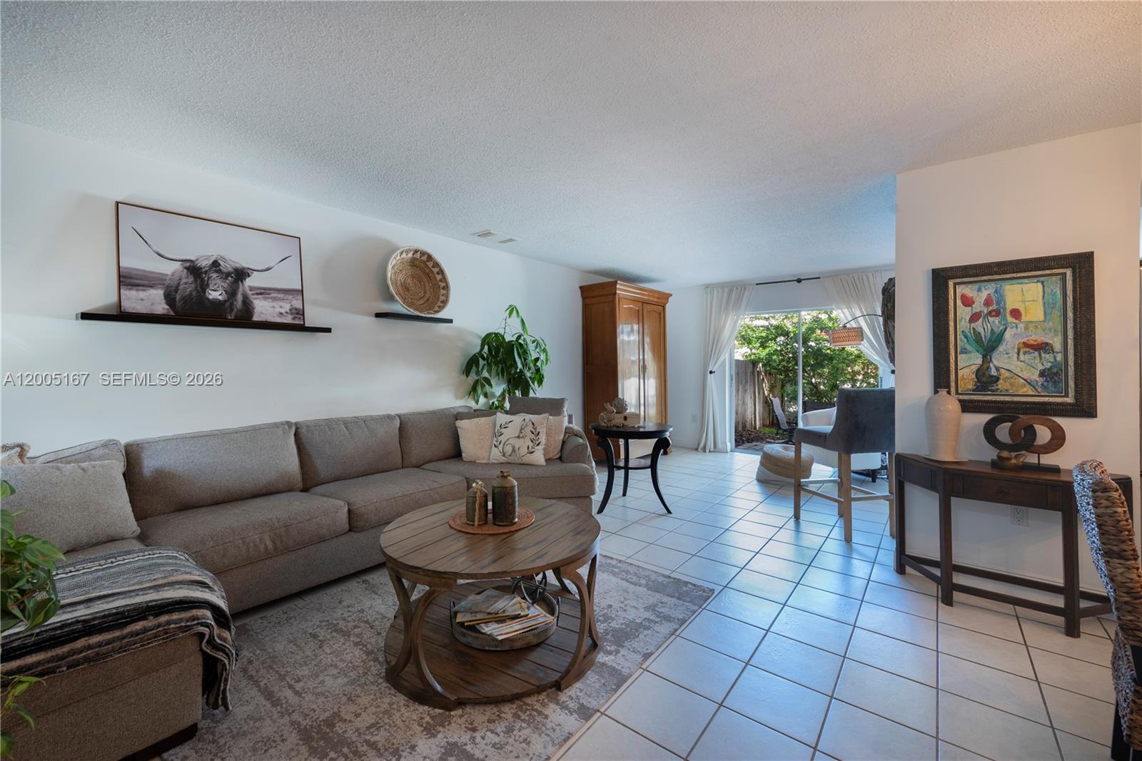 A living room features a gray sectional sofa, a round wooden coffee table, and tile flooring — 20801 SW 83rd Ave, Cutler Bay FL 33189, CUTLER BAY, FL