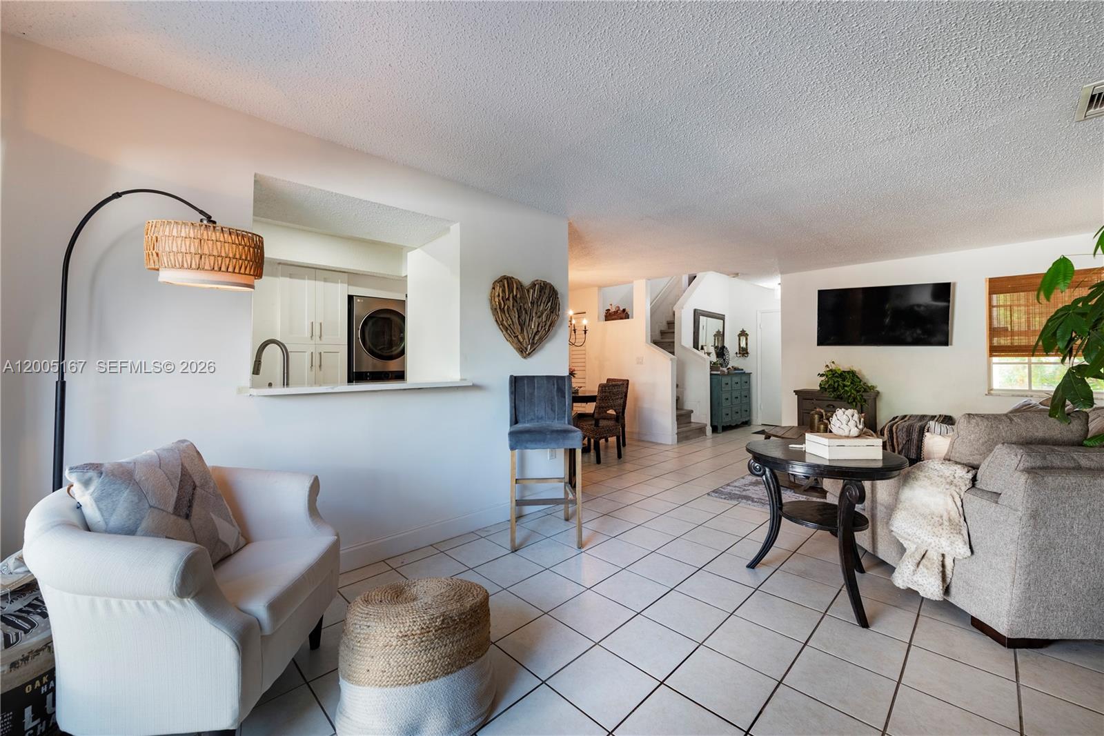 A living room with white tile floors, a pass-through kitchen window, and a staircase — 20801 SW 83rd Ave, Cutler Bay FL 33189, CUTLER BAY, FL