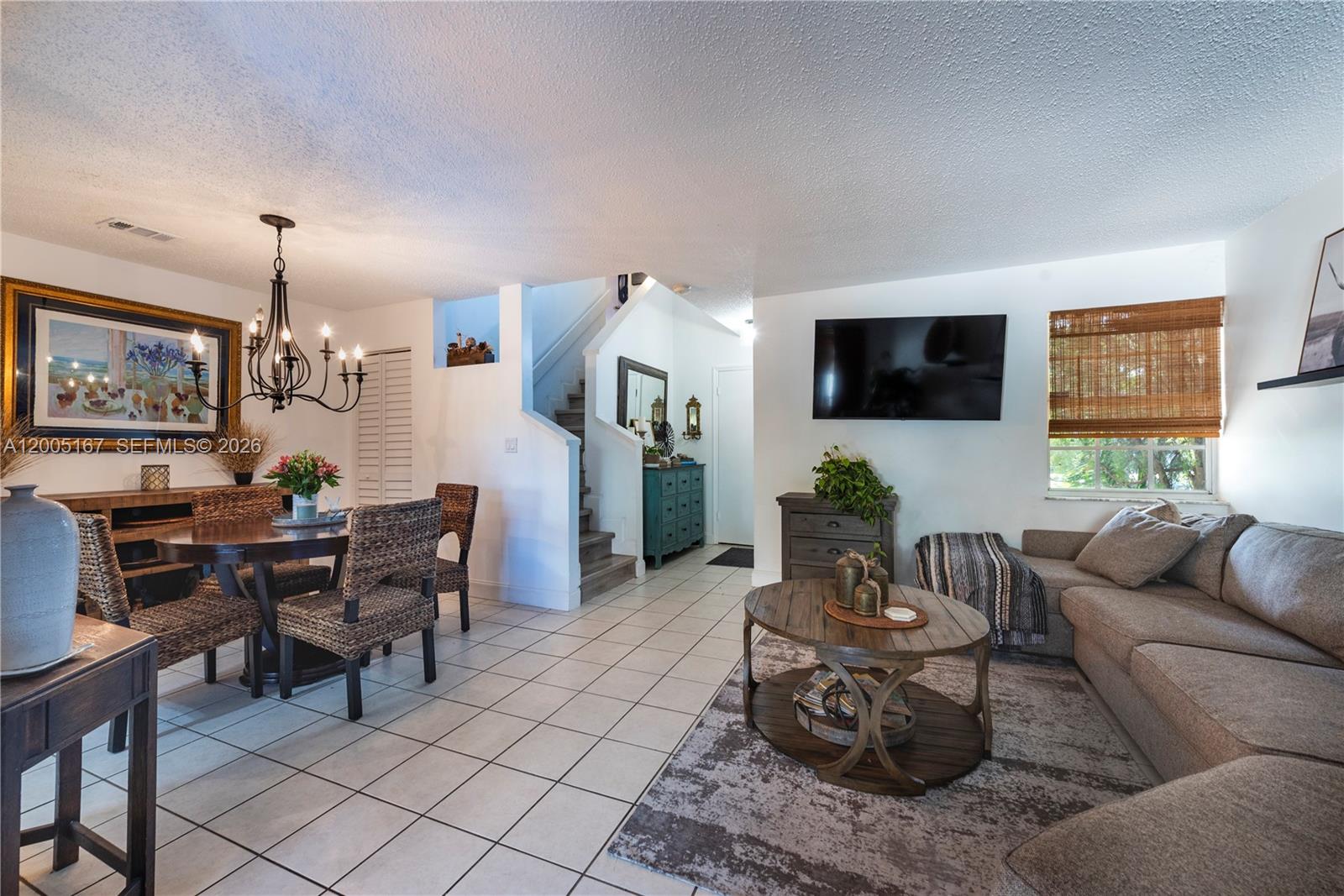 An open-concept living and dining area features tile flooring, a staircase, and a wall-mounted television — 20801 SW 83rd Ave, Cutler Bay FL 33189, CUTLER BAY, FL