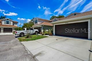 A white pickup truck is parked in the driveway of a suburban residential building — 5246 NEIL DRIVE, ST PETERSBURG, FL