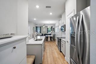 A kitchen with light gray cabinets, stainless steel appliances, and wood-look tile flooring — 5246 NEIL DRIVE, ST PETERSBURG, FL