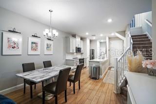 A dining area with a marble-topped table and chairs sits adjacent to a modern kitchen — 5246 NEIL DRIVE, ST PETERSBURG, FL