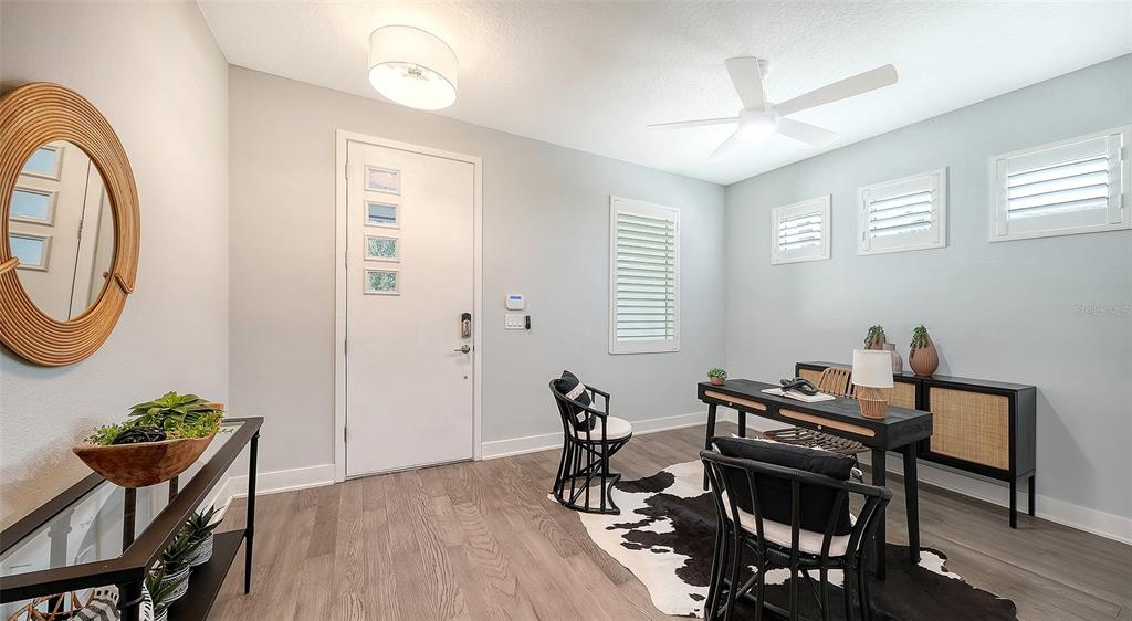A home office features a desk, two chairs, a cowhide rug, and a round mirror — 2554 FLOYD STREET, SARASOTA, FL