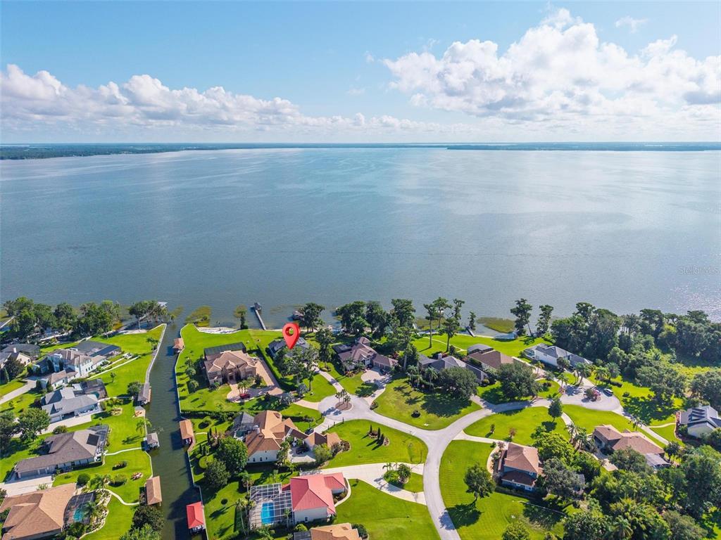 An aerial view shows a residential neighborhood situated along a large lake — 7303 BIRDS NEST COURT, YALAHA, FL