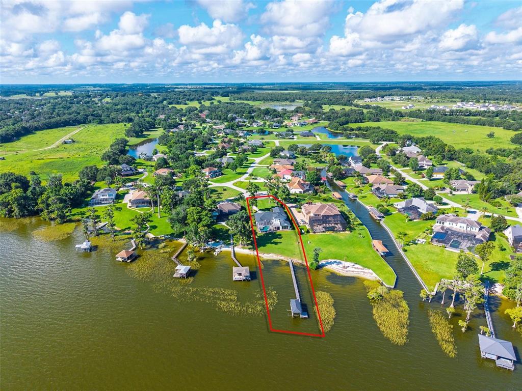 An aerial view shows a waterfront house with a private dock and pool — 7303 BIRDS NEST COURT, YALAHA, FL