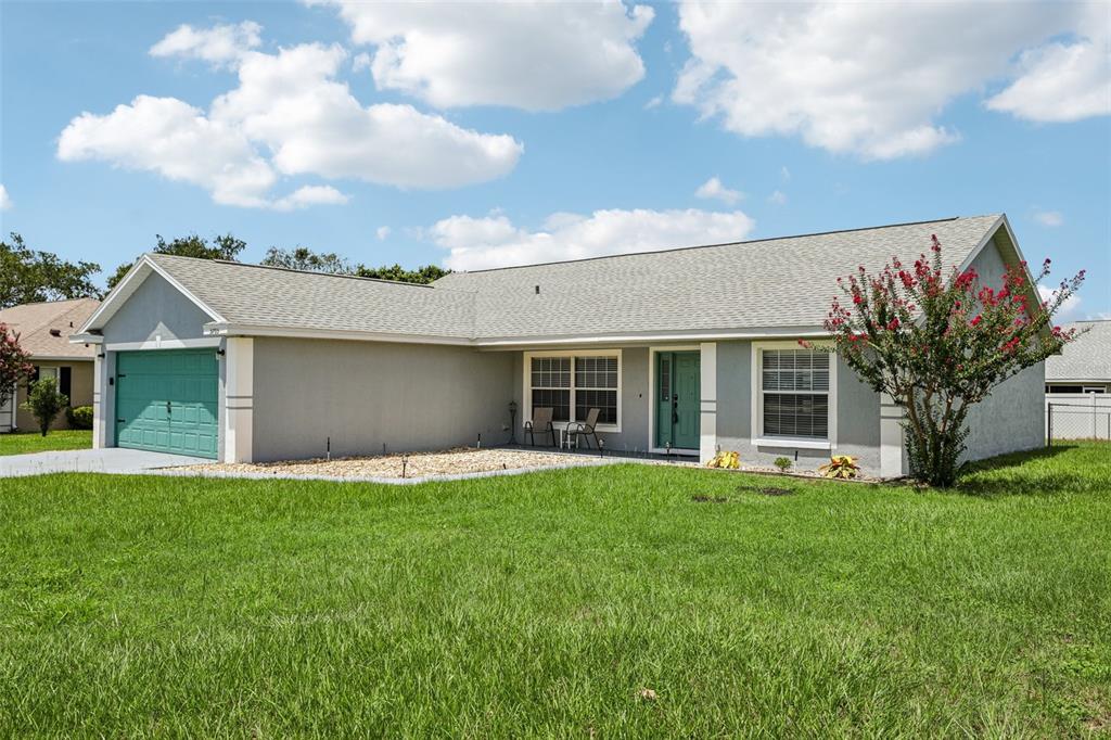 A single-story house with a gray exterior, a teal garage door, and a front lawn — 5705 SW 89TH PLACE, OCALA, FL