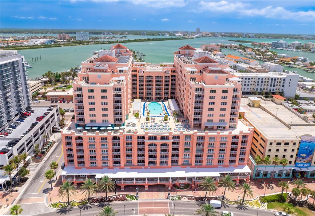 An aerial view of a large pink hotel complex with a central swimming pool area — 301 S GULFVIEW BOULEVARD UNIT 604, CLEARWATER BEACH, FL