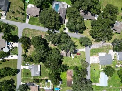 This is an aerial view of a residential neighborhood with houses, trees, and paved streets — 35833 LAKESHORE DRIVE, DADE CITY, FL