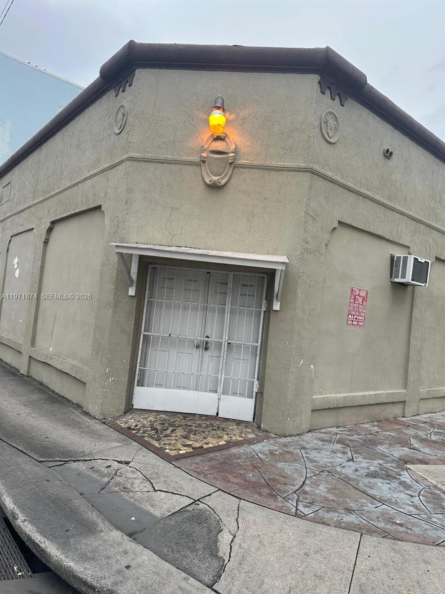 The exterior of a tan building features a double door with a white security gate — 5301 NW 17th Ave, Miami FL 33142, MIAMI, FL