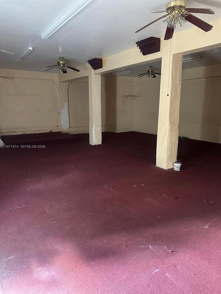 An interior view shows a large, open room with red carpeting and support columns — 5301 NW 17th Ave, Miami FL 33142, MIAMI, FL
