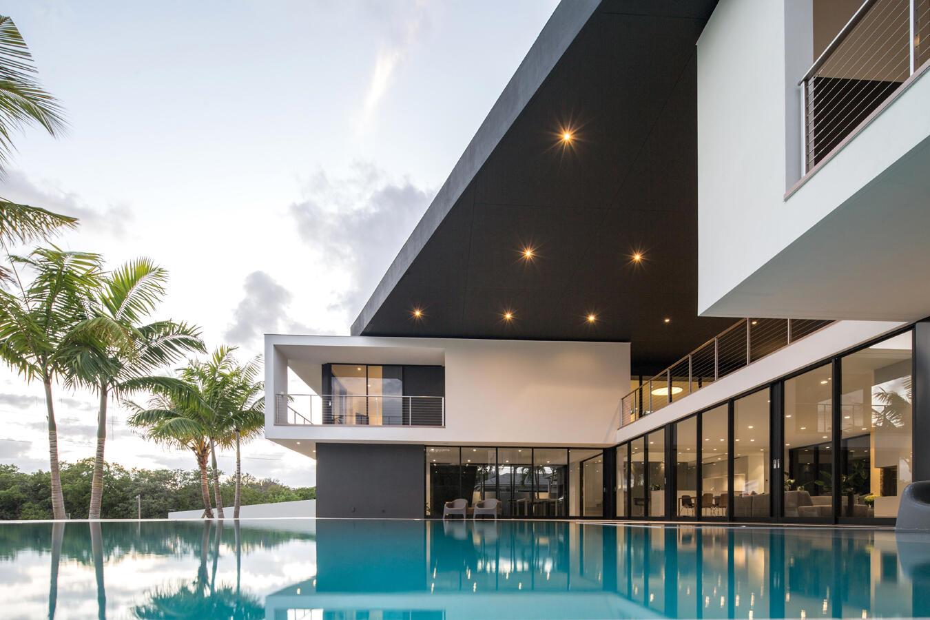 A modern two-story house with a large black overhang and pool in the foreground — 5706 Holly Lane, Jupiter FL 33458, JUPITER, FL