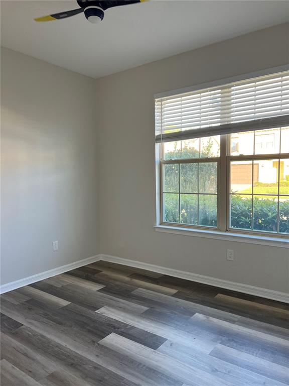An empty room features light gray walls, wood-look flooring, and a window with white blinds — 17392 BAL HARBOUR DRIVE, WINTER GARDEN, FL