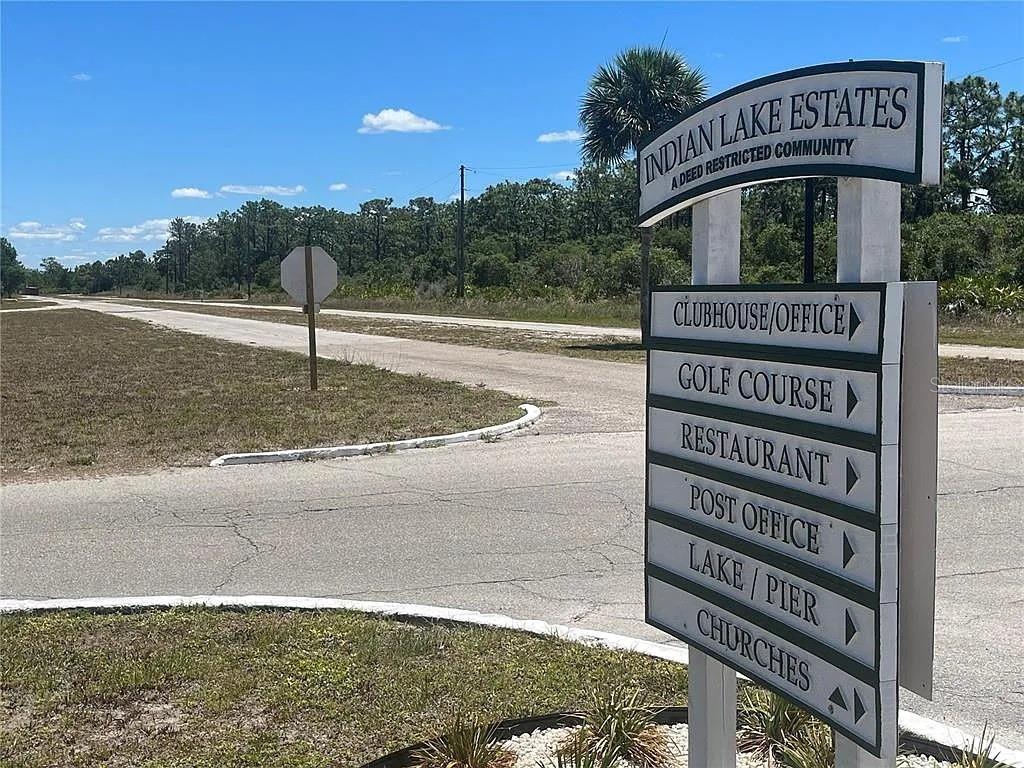 A sign for Indian Lake Estates stands at the entrance to a paved road — DAYTONA DRIVE, INDIAN LAKE ESTATES, FL