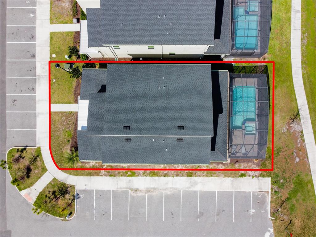 An aerial view shows a residential building with a screened-in pool and adjacent parking lots — 2901 PROTAGONIST STREET, KISSIMMEE, FL