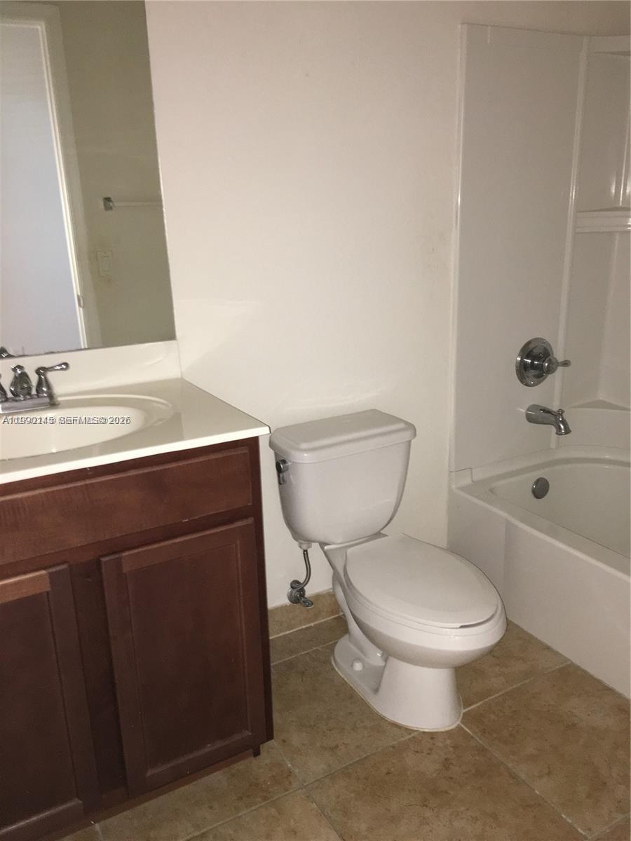 A bathroom features a dark wood vanity, a white toilet, and a shower-tub combination — 10870 NW 88th Ter # 223, Doral FL 33178, DORAL, FL