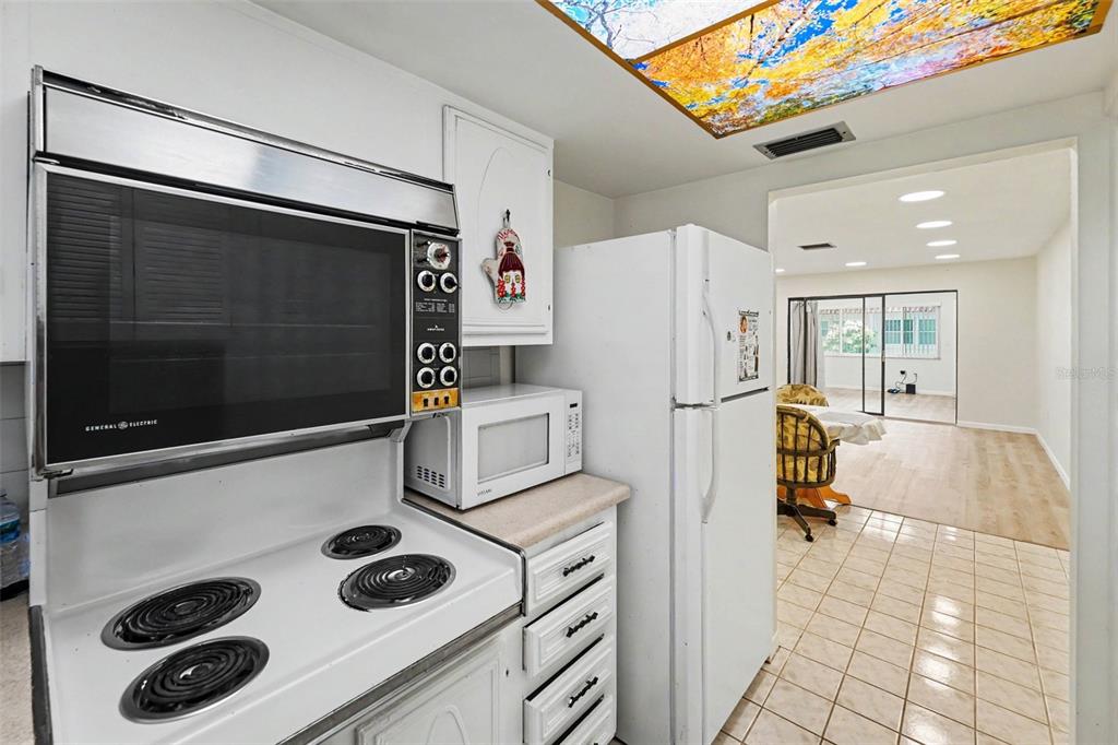 A kitchen features white cabinets, a white stove, a microwave, and a white refrigerator — 5870 38TH AVENUE N UNIT 43, ST PETERSBURG, FL